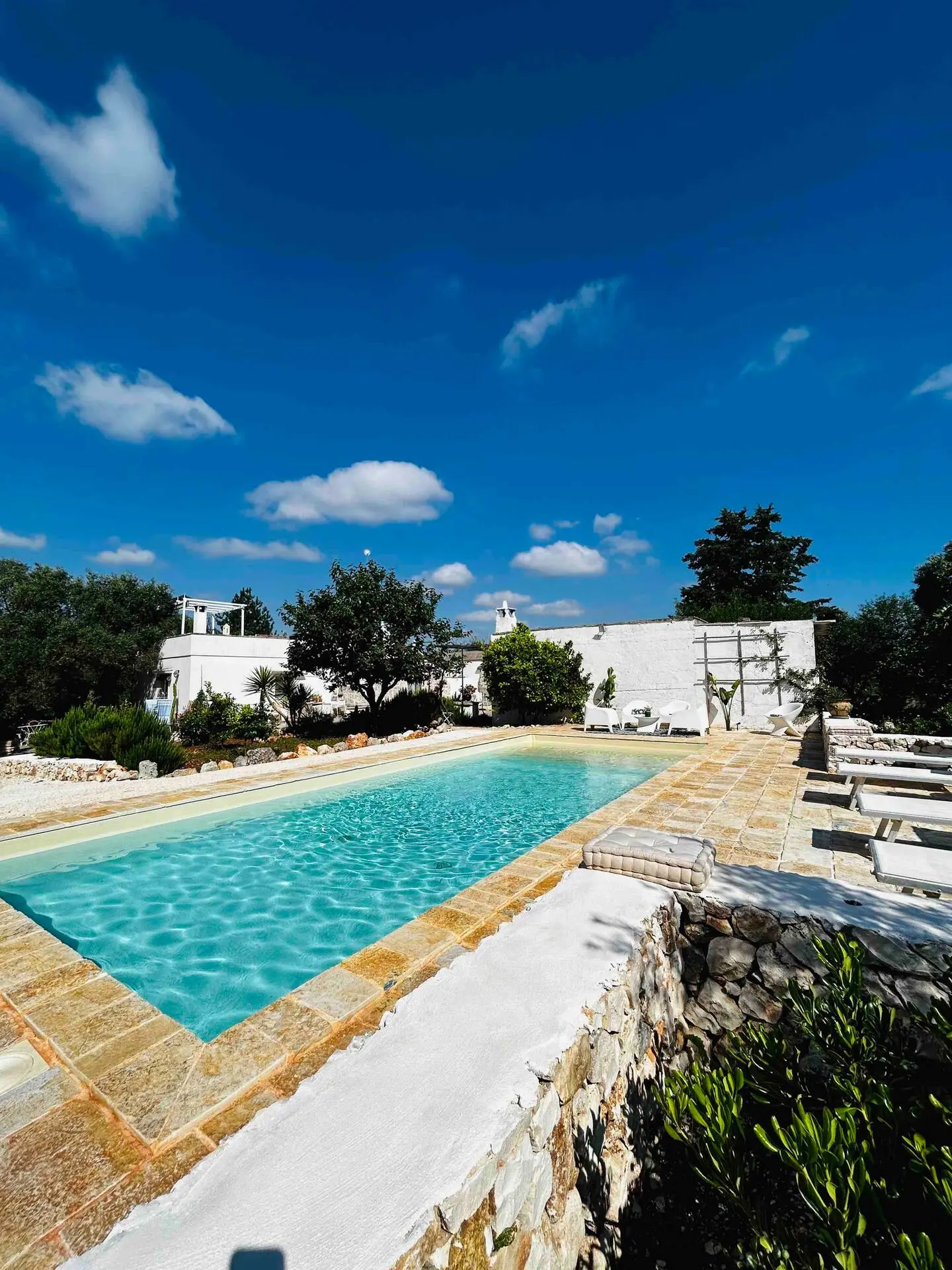 La piscine bordée de pierre, le trullo en arrière-plan